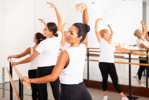 Group of women engaged in classical ballet in a dance studio perfoms a choreographic exercise that promotes proper ..coordination of movements photo