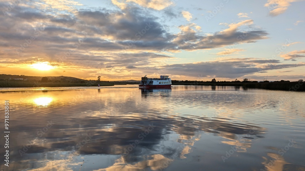 Corrib princes touristic boat cruise on Corrib river at sunset with sky reflection in water, nature background, Galway, Ireland