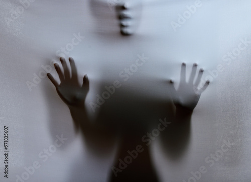 Person, shadow and sheet with ghost for horror, torment or evil spirit on a gray studio background. Closeup, hands and silhouette of apparition, spirit or spectre for trauma, fear or nightmare asylum