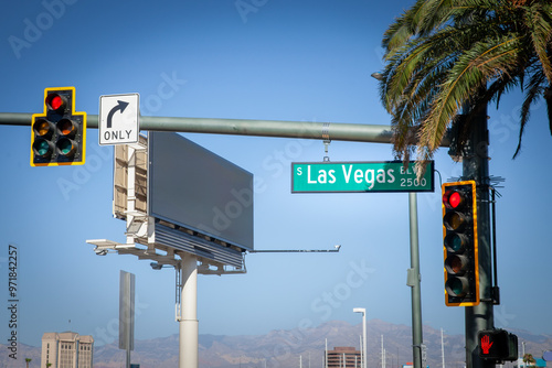 A typical American intersection on Las Vegas Boulevard (or las vegas strip), featuring traffic lights, road signs, and palm trees, symbolizing the urban landscape of Las Vegas, Nevada.