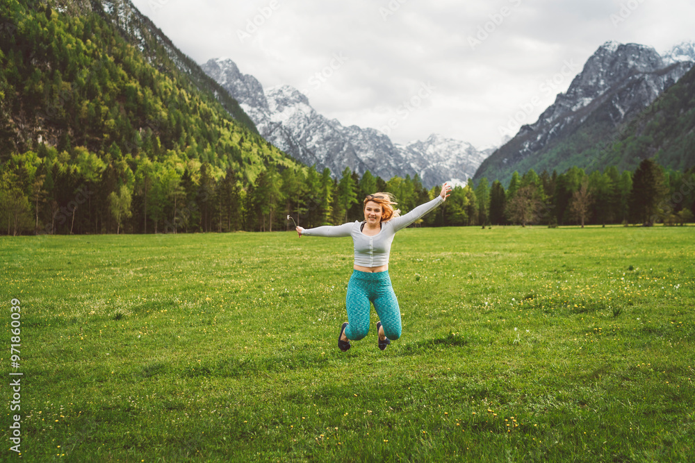 Obraz premium Happy friends taking selfie in the mountain valley in Alps. Enjoying nature, running, smiling, doing exercise on the grass field.