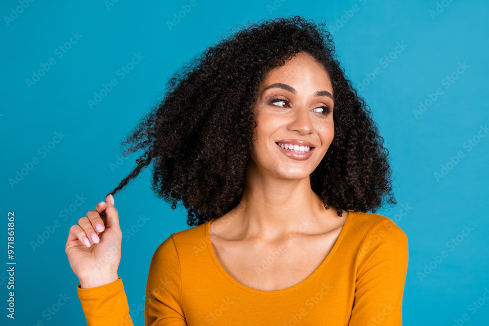 Fototapeta premium Photo portrait of pretty young girl hold hair strand hairdo look empty space wear trendy orange outfit isolated on blue color background