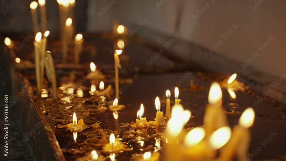 Candles burning in a church or altar during prayer and worship. Lighting the dark room candles lit by visitors and worshipers are burning inside a holy sacred place for christianity Candles burning in a church or altar during prayer and worship. Lighting the dark room candles lit by visitors and worshipers are burning inside a holy sacred place for christianity