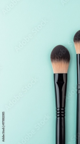 A set of professional makeup brushes lies beautifully on a light blue background, highlighting their sleek design and quality bristles