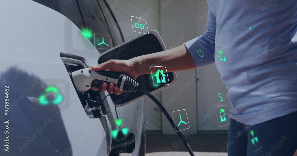 Image of energy and ecology icons over caucasian man charging electric car Image of energy and ecology icons over caucasian man charging electric car