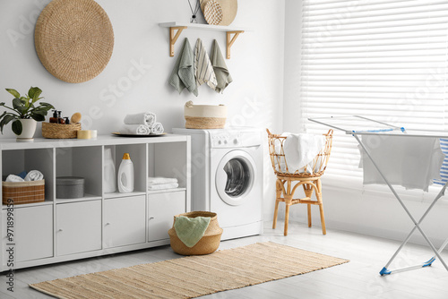 Washing machine, towels and detergents in laundry room photo