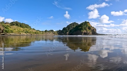 Black Sand of Bethells Beach, framed by the dramatic cliffs situated along the picturesque Waitakere Coast on New Zealand's North Island photo