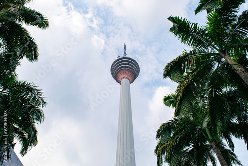 Photography The kuala lumpur tower is standing tall surrounded by palm trees on a beautiful
