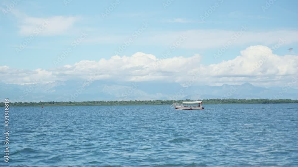 Tour boat sailing in Shkodra or Skadar Lake in Montenegro during summer day. Beautiful day with blue sky and clouds as tourists enjoy a tour in famous lake in balkan country. Peaceful calm waters Tour boat sailing in Shkodra or Skadar Lake in Montenegro during summer day. Beautiful day with blue sky and clouds as tourists enjoy a tour in famous lake in balkan country. Peaceful calm waters