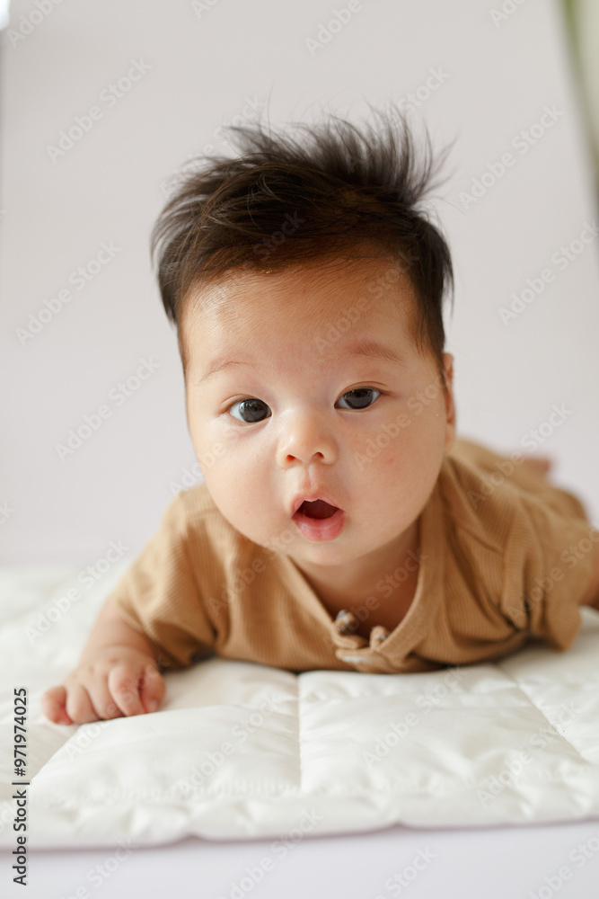 a close up of a baby laying on a bed a close up of a baby laying on a bed