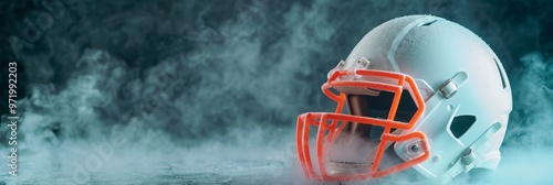 A white football helmet sculpted entirely from ice sits in a cloud of white smoke. The helmet is placed in the foreground with the smoke filling the background, suggesting the idea of passion, competi photo