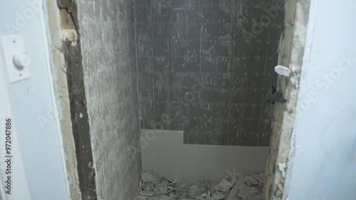 The bathroom shower is under construction. The tiles are being replaced.