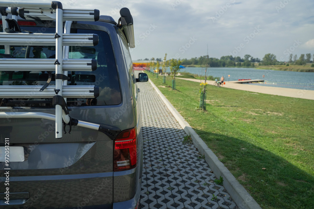 samochód turystyczny zaparkowany nad plażą jeziora w letni słoneczny dzień
