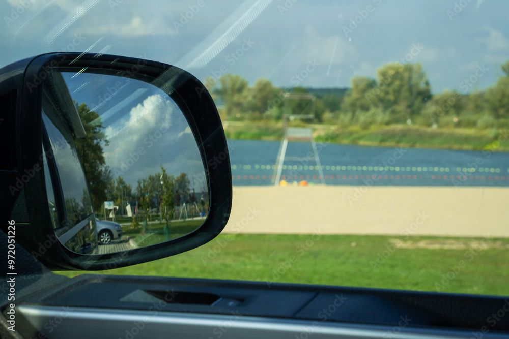 samochód turystyczny zaparkowany nad plażą jeziora w letni słoneczny dzień