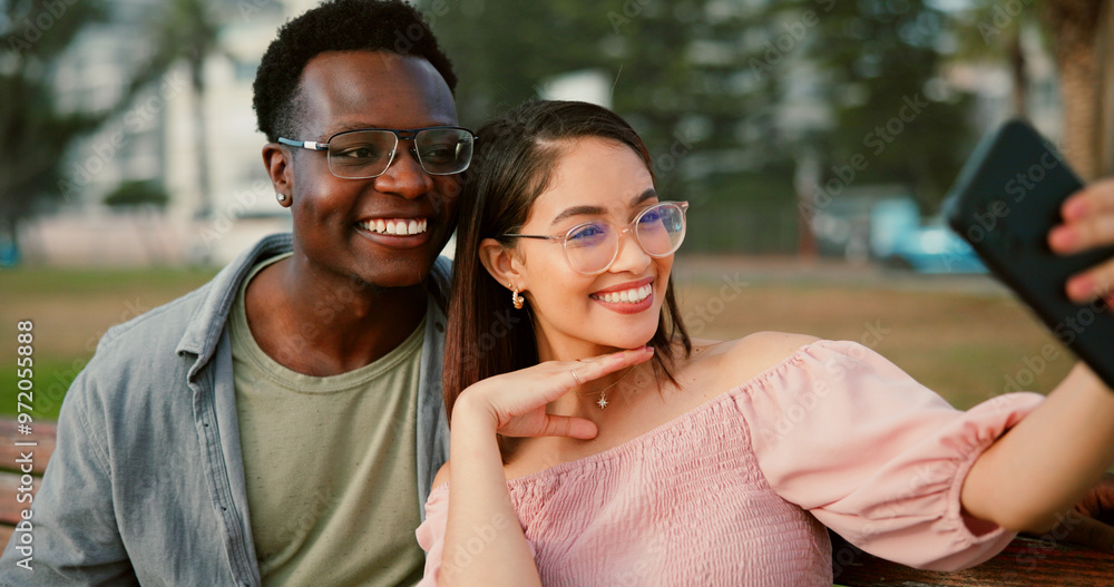 Happy, selfie and couple on bench in park with fun memory, social media post and interracial relationship. Love, photography and man with woman smile on romantic date with outdoor bonding together Happy, selfie and couple on bench in park with fun memory, social media post and interracial relationship. Love, photography and man with woman smile on romantic date with outdoor bonding together