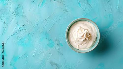 Handcrafted Greek yogurt in a dish on azure backdrop from above with room for text. Natural unflavored Greek yogurt labneh mascarpone creme fraiche for nutritious morning meal photo