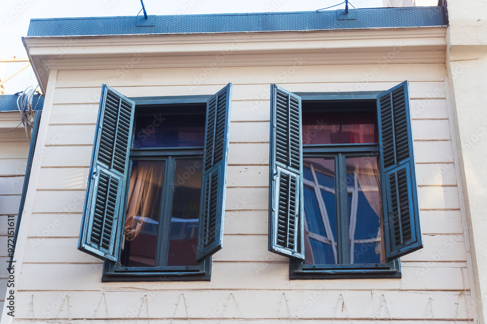 two windows with wooden shutters on the old house two windows with wooden shutters on the old house