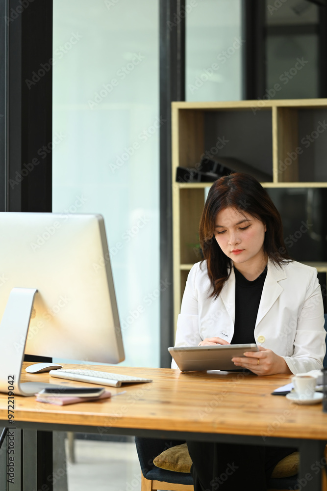 Professional businesswoman analyzing sales statistics data on her digital tablet Professional businesswoman analyzing sales statistics data on her digital tablet