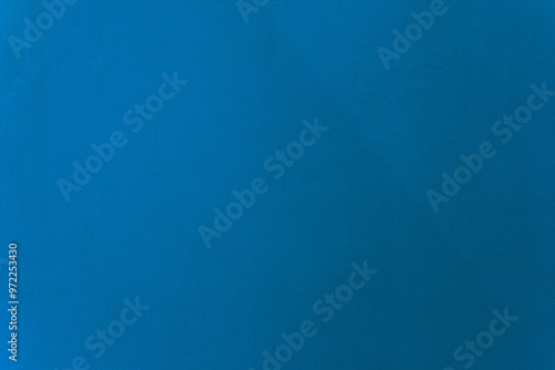 Light navy blue color paint on cement wall texture as background.
