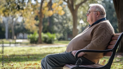 Senior with obesity sitting on a park bench, gazing at the surroundings, reflecting on the effects of weight on outdoor activities