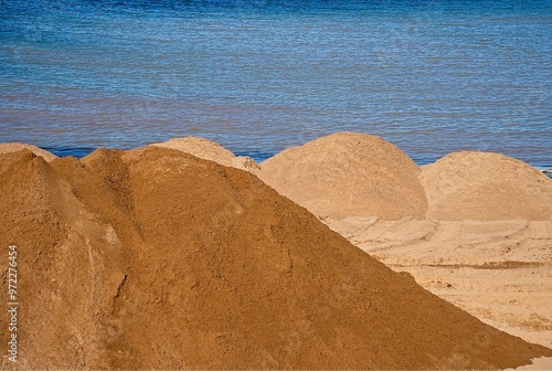 sand dunes ready to be spread on the beach by heavy machinery