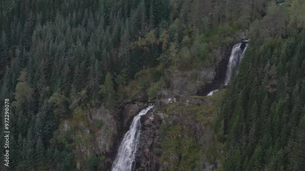 Two waterfalls cascading down a mountainside in Norway next to a road. Two waterfalls cascading down a mountainside in Norway next to a road.