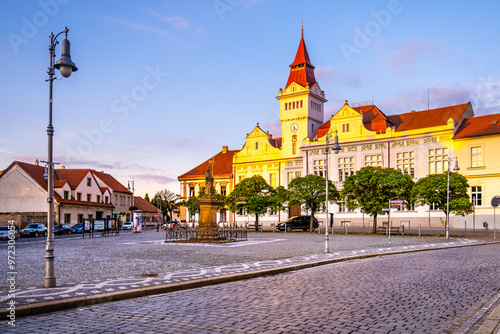 Marianske Square in Stara Boleslav glows in the evening light as the Town Hall stands majestically nearby. The quiet square invites evening strolls amid historical architecture. photo