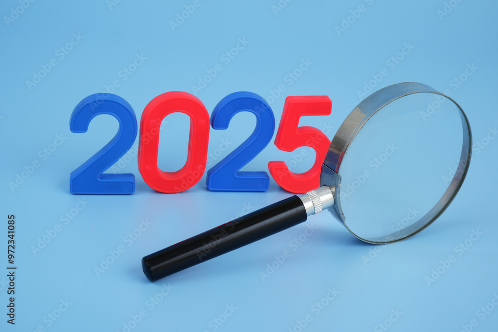 Experts analytics and prognosis for year 2025. Magnifying glass and numbers 2025 on blue background. Experts analytics and prognosis for year 2025. Magnifying glass and numbers 2025 on blue background.