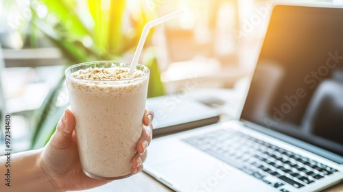 Smoothie in Hand by Laptop. Healthy Breakfast Drink at Work or Home Office
