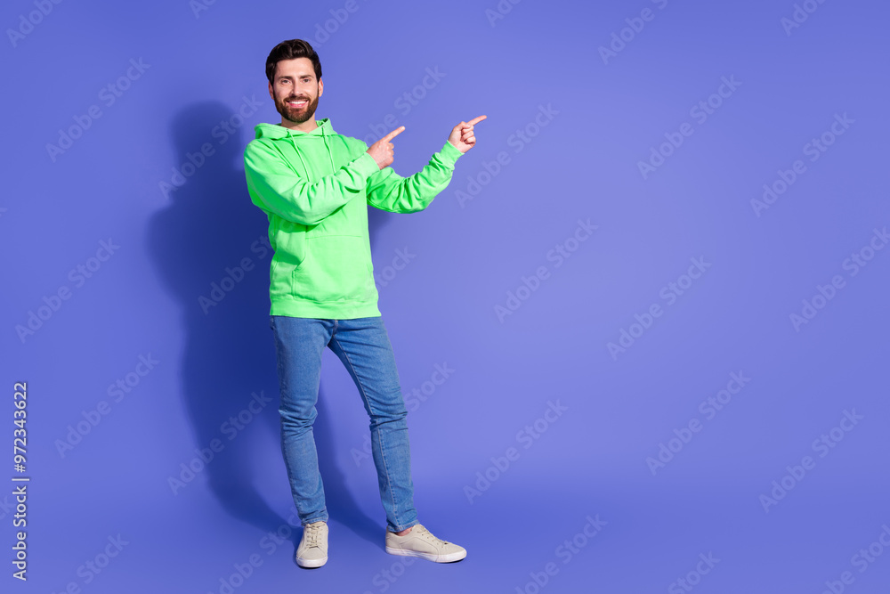 Full body photo of attractive young man point empty space dressed stylish green clothes isolated on violet color background Full body photo of attractive young man point empty space dressed stylish green clothes isolated on violet color background