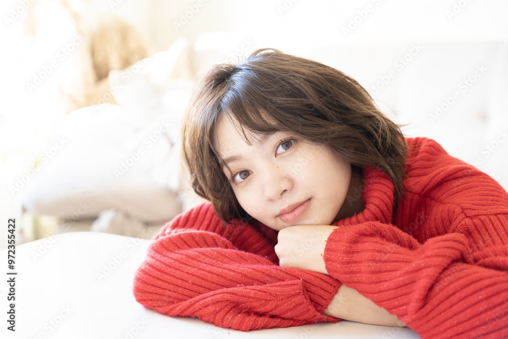 赤いニットを着てこちらを見ている女性 赤いニットを着てこちらを見ている女性