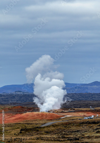 A large cloud of steam rises from a geothermal power plant in the distance. Reykjanes power station