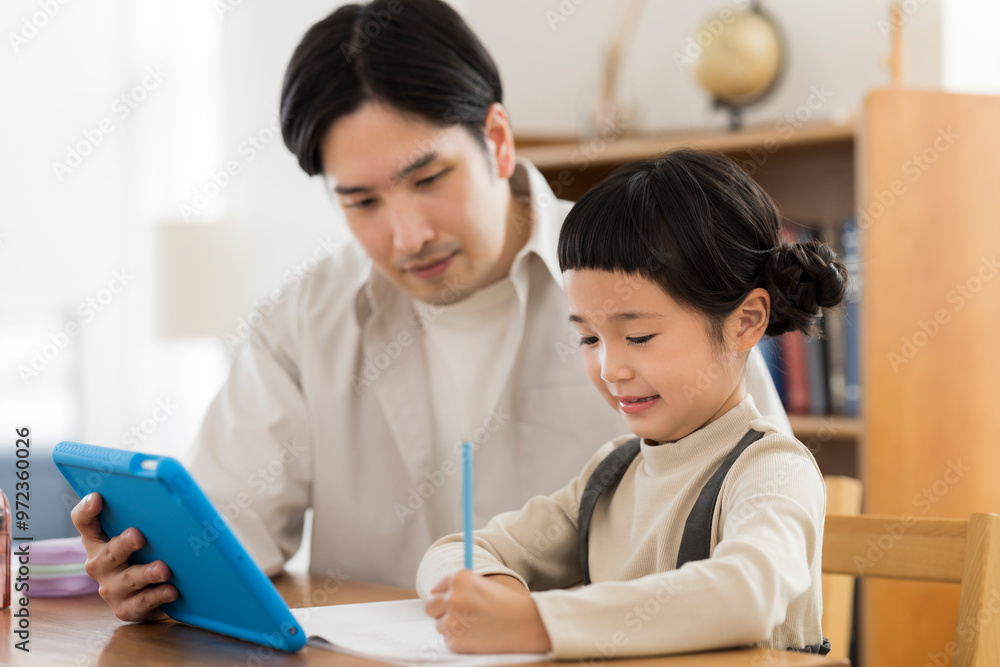 タブレットPCで学習をする女の子と父親