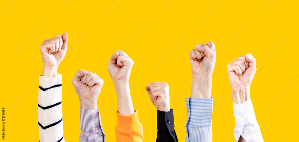 Fototapeta premium Group of activists raising their fists in the air. Fists in the air yellow background
