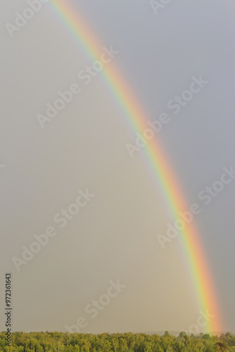 Rainbow against sunset sky. Natural background. Weather after rain.