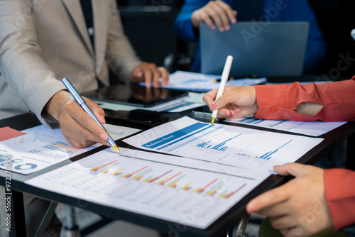 Business team using a calculator to calculate the numbers of statistic business profits growth rate on documents graph data, desk in the office.