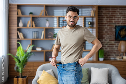 Φωτογραφία Portrait of a young smiling Indian man standing at home in front of the camera w