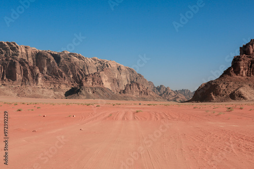 Explore the stunning red sands and majestic cliffs of Wadi Rum Desert in Jordan during a bright sunny day