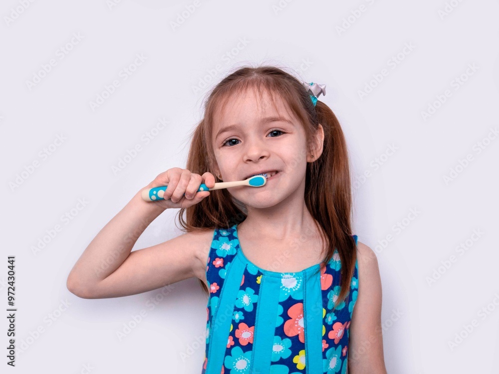 A little blonde girl is brushing her teeth, holding a brush in her hand. The concept of proper oral care, pediatric dentistry A little blonde girl is brushing her teeth, holding a brush in her hand. The concept of proper oral care, pediatric dentistry