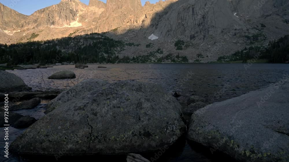 Riverbed and jagged peaks of Cirque of the Towers in the Wind River Range with light glowing on ridges
