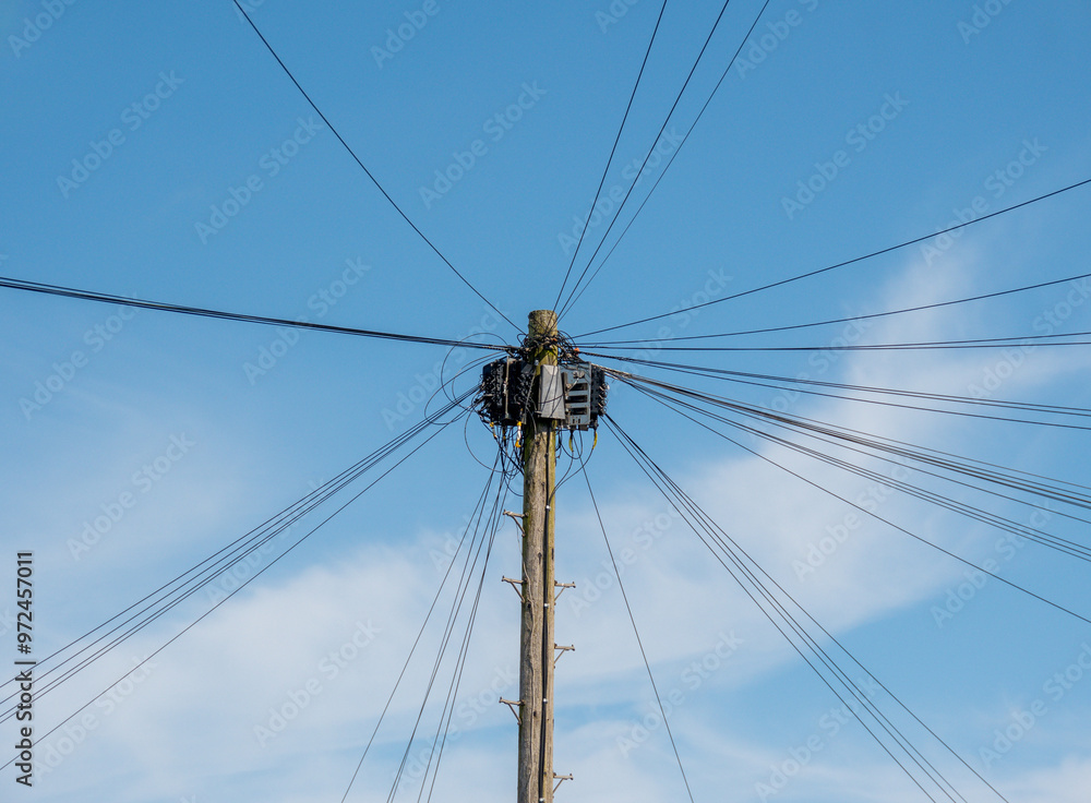 Cables and wires on a telegraph pole against a blue sky. Telephone and communication image. Science and technology concept. Cables and wires on a telegraph pole against a blue sky. Telephone and communication image. Science and technology concept.