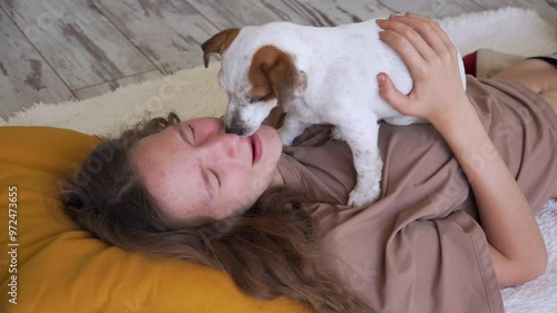 Teen girl playing with puppy dog at home