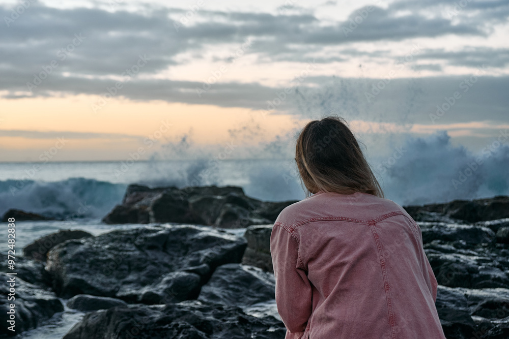 Beautiful woman is enjoying the sunset over the rocky beach, tropical island, ocean bay Beautiful woman is enjoying the sunset over the rocky beach, tropical island, ocean bay