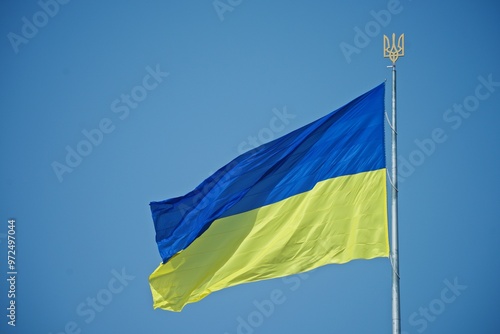 a large Ukrainian flag against the background of the blue sky