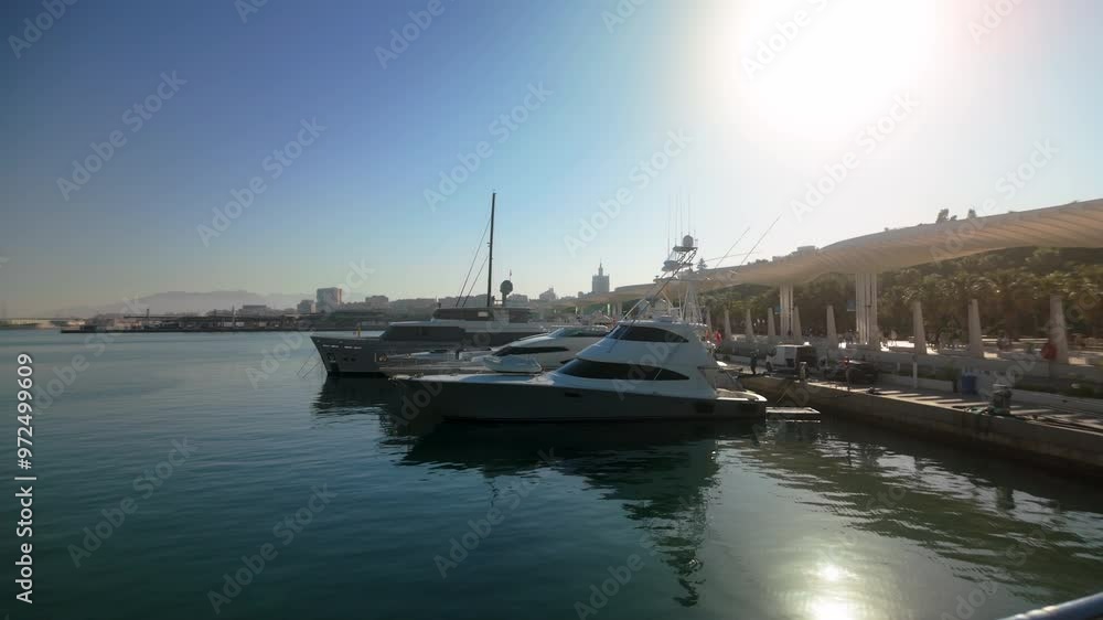 Yachts moored at the dock on a sunny day with the Málaga skyline in the background Yachts moored at the dock on a sunny day with the Málaga skyline in the background