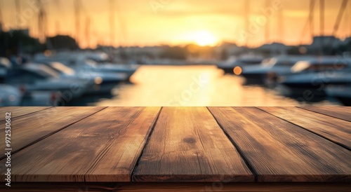 A wooden table in the foreground with a sunset and boats in the background.