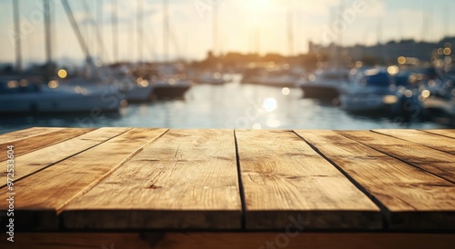 A wooden table in the foreground with a blurred marina and boats in the background at sunset.