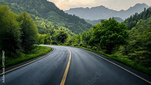 Scenic winding road through lush green mountains at dusk shows the beauty of nature in tranquil surroundings