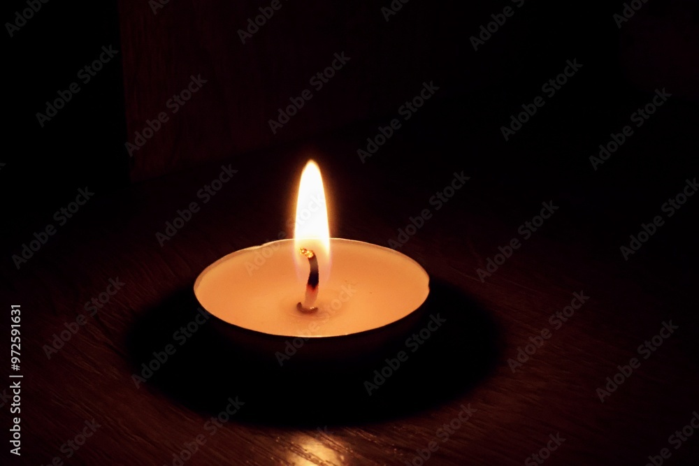 a small candle burns on a dark background a small candle burns on a dark background