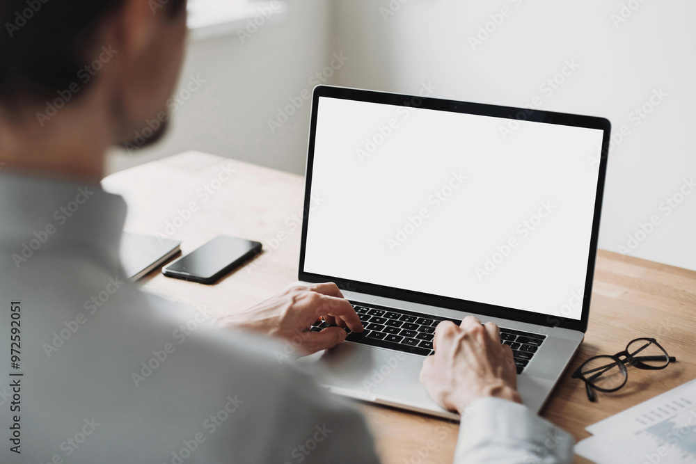 Young man using laptop computer with blank empty mockup screen. Business man working at home. Freelance, student lifestyle, e-learning, shopping online, web site, technology concept Young man using laptop computer with blank empty mockup screen. Business man working at home. Freelance, student lifestyle, e-learning, shopping online, web site, technology concept